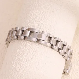 Detail of silver stainless steel strap bracelet with laser-etched floral patterns on links
