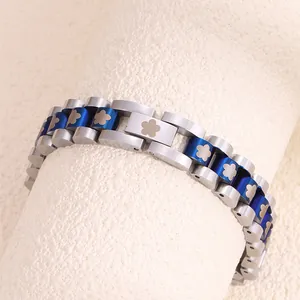 Detail of silver and blue watch-band style bracelet with small flower links on a scroll
