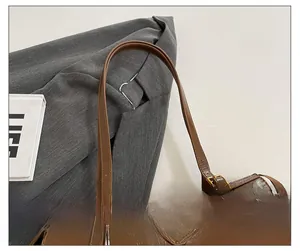 Detail einer braunen Ölwachs-Lederhandtasche mit Schultergurt und Metallbeschlägen