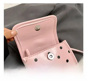 Détail du petit sac rose à pois avec fermoir magnétique en argent et texture en similicuir