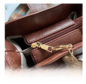 Détail du sac seau marron vintage avec fermeture éclair dorée et charm ours mignon