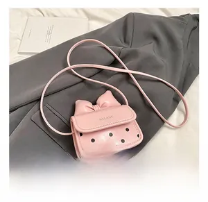 Détails d'un mini sac rose brillant avec nœud élégant et motif à pois moderne