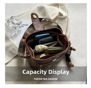 Aperçu de la capacité du sac seau en cuir marron avec téléphones, portefeuille et parfum