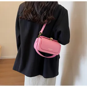 Pink leather crossbody bag with gold buckle shown on black blazer for fashion contrast