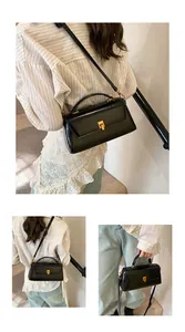Detail showing high-shine black patent leather square bag with gold metal clasp