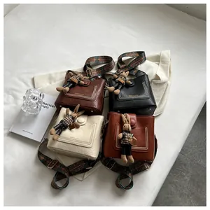 Détail de sacs seaux vintage en quatre couleurs avec poupée pied-de-poule et bandoulières
