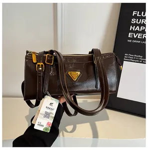 Detail der vintage dunkelbraunen polierten Leder-Achseltasche mit goldenem Logo