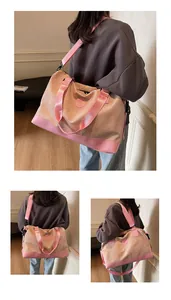Vue détaillée du grand sac de voyage en toile avec lanières en cuir rose et bandoulière