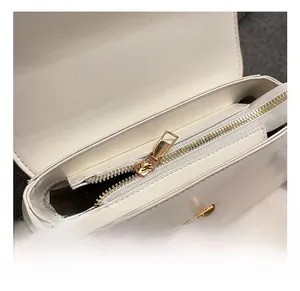 Macro view of white square bag featuring premium gold zipper and herringbone fabric lining