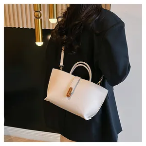 Detail of white lychee pattern leather handbag with elegant gold metal twist lock