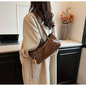 Deep brown wax leather shoulder bag featuring a cute bear pendant and flap closure