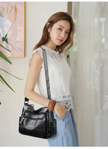 Close-up detail of black leather tote bag with multi-pocket design and kangaroo logo