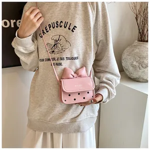 Détail du mini sac bandoulière en similicuir rose avec nœud et motifs à pois noirs
