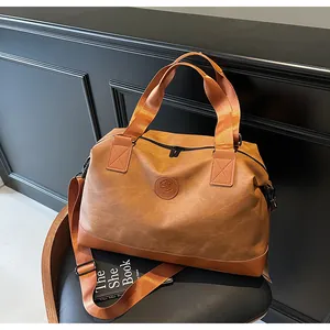 Détail du sac de voyage marron vintage avec base renforcée et sangle sur une chaise