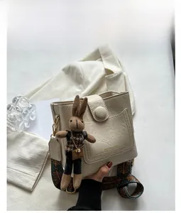 Détail du sac seau blanc vintage avec bandoulière ethnique et breloque lapin