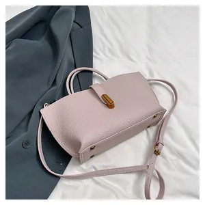 Top view of a purple leather tote bag showing grainy texture and a metal turn-lock closure