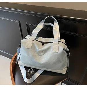 Gros plan d'un sac de voyage bleu clair au fini mat sur un siège en cuir noir