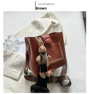 Détail du sac seau marron avec bandoulière brodée ethnique et breloque lapin en peluche