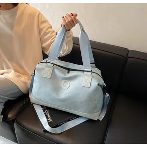 Détail du sac de voyage bleu clair à texture marbre avec base renforcée sur sofa