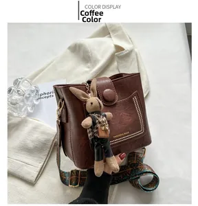 Vue détaillée du sac seau en cuir café avec texture rétro et bandoulière de style ethnique