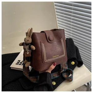 Détail du sac seau marron vintage avec cuir texturé et bandoulière bohème