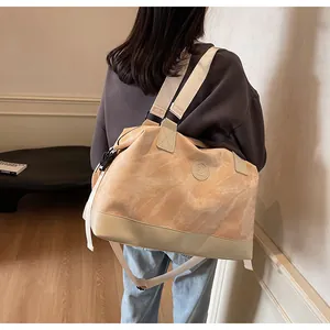 Détail du grand sac de voyage orange clair montrant sa capacité porté par un mannequin