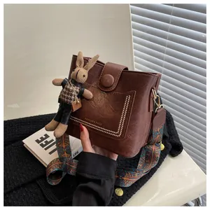 Sac seau rétro marron avec texture litchi, bandoulière ethnique et lapin