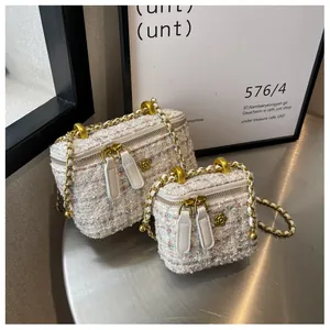 Détail de mini sacs en tweed avec garnitures florales dorées et bandoulière chaîne