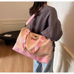 Vue détaillée du grand sac de voyage rose porté par un mannequin dans un intérieur