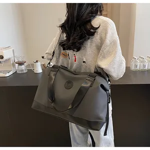 Vue arrière d'un mannequin portant un grand sac de voyage gris foncé en intérieur