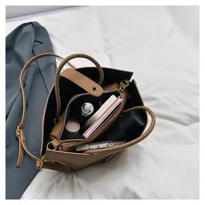 Interior detail of large brown leather tote showing central zip pocket and compartments