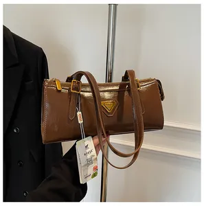 Detailansicht der braunen Schultertasche aus Ölleder mit goldenen Beschlägen und Logo