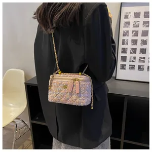 Détail du sac bandoulière en tweed sur un mannequin portant un blazer noir contrasté