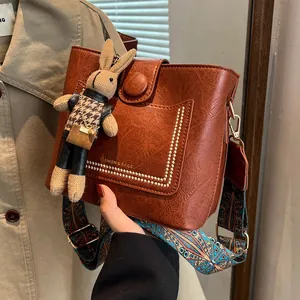 Sac seau rétro marron avec bandoulière ethnique large et breloque lapin