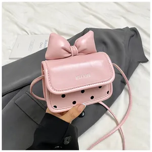 Détail du mini sac rose orné d'un grand nœud et d'une texture en cuir poli