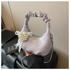 Detail view of purple ruched cloud bag showing pearl pendant and chain strap
