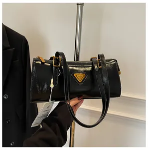 Nahaufnahme einer schwarzen Öl-Wachs-Leder-Zylindertasche mit goldenen Details
