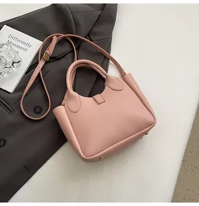 Détail du sac seau en cuir rose à grain litchi avec clous de protection dorés au fond