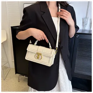 Detailansicht der cremefarbenen Krokodilmuster-Box-Tasche mit goldenem T-Verschluss