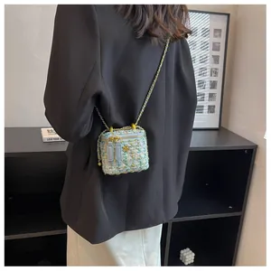 Vue détaillée du mini sac bandoulière en tweed avec chaîne sur le mannequin