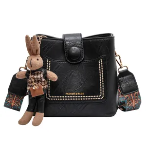 Sac seau noir en similicuir grainé avec rivets dorés et bandoulière bohème