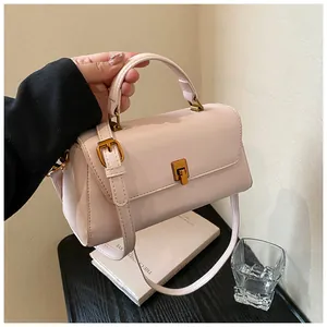 Detailed shot of a soft pink mini crossbody bag with gold hardware and a twist-lock closure