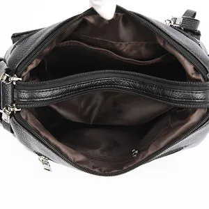 Black leather crossbody bag with multiple zip compartments and brown fabric lining