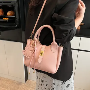 Sac seau en cuir grainé rose avec poignée supérieure et charmant pendentif chien