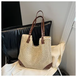 Close-up of woven mesh beach bag with brown leather handles and silver rivet accents