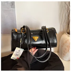 Detaillierte Nahaufnahme einer schwarzen glänzenden Boston-Tasche mit goldenen Beschlägen