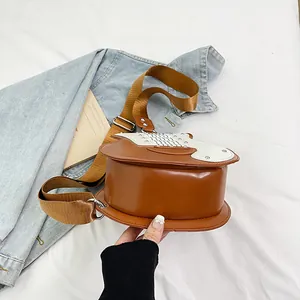 Dettaglio della borsa a tracolla marrone a forma di chitarra con ampia cinghia regolabile