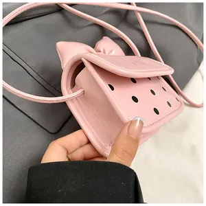 Gros plan du mini sac rose à pois avec nœud 3D et détails en similicuir de haute qualité