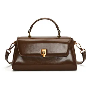 Chic brown patent leather top handle bag with vintage gold twist lock in minimalist style