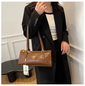 Detailansicht der braunen Tasche aus Ölwachsleder mit goldener Schnalle und Gurt